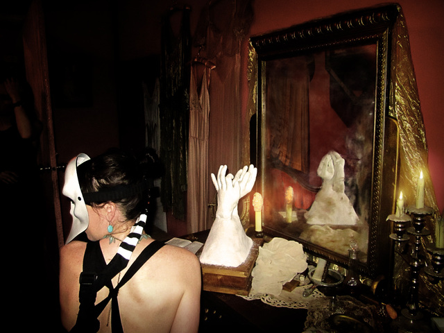 Audience member wearing the augmented mask seated at a mirror portal
